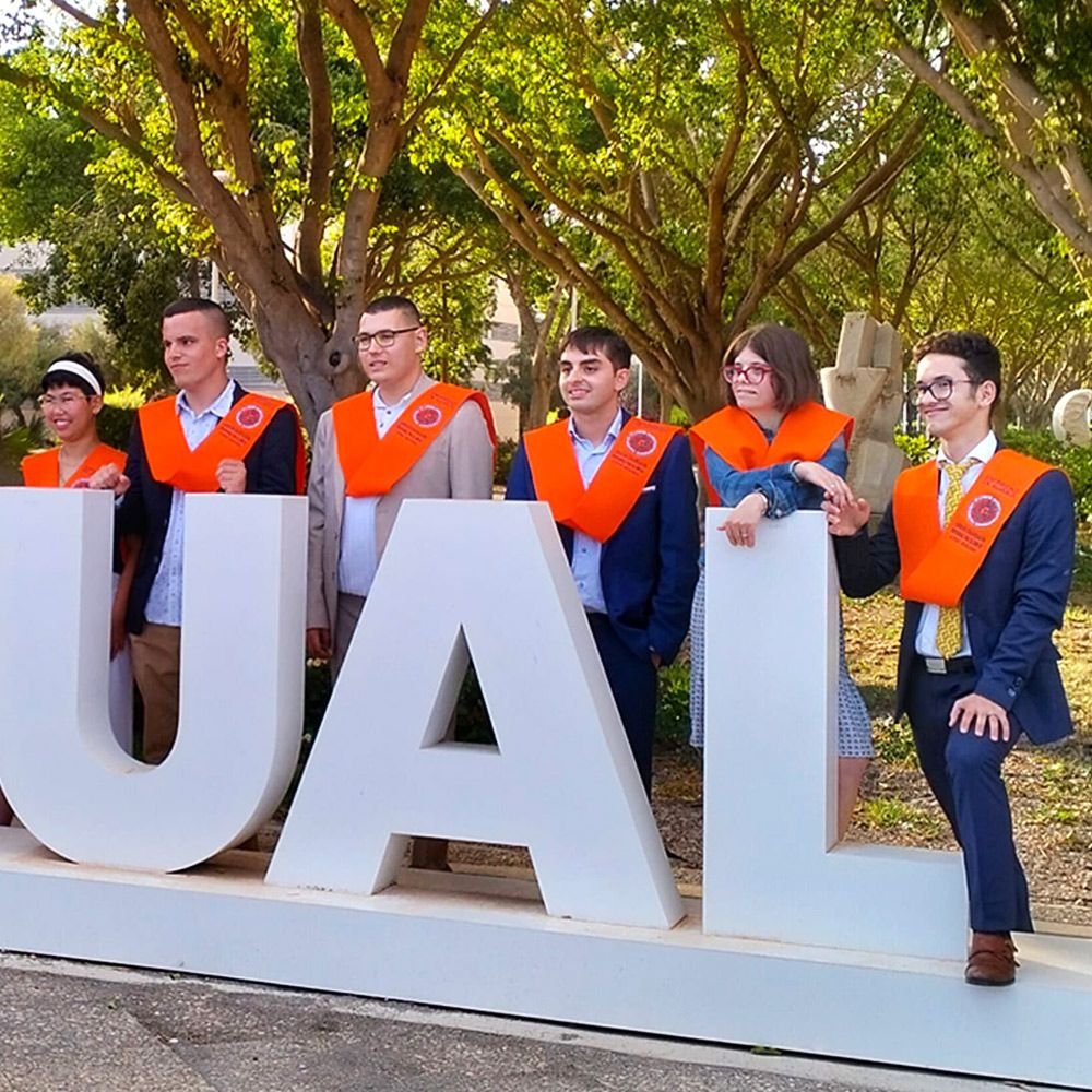 UNIdiversidad, Encabezado de la Sección. Foto de participantes de UNIdiversidad con las bandas de graduación en el campus de la Universidad de Almería (Escultura SoyUAL)